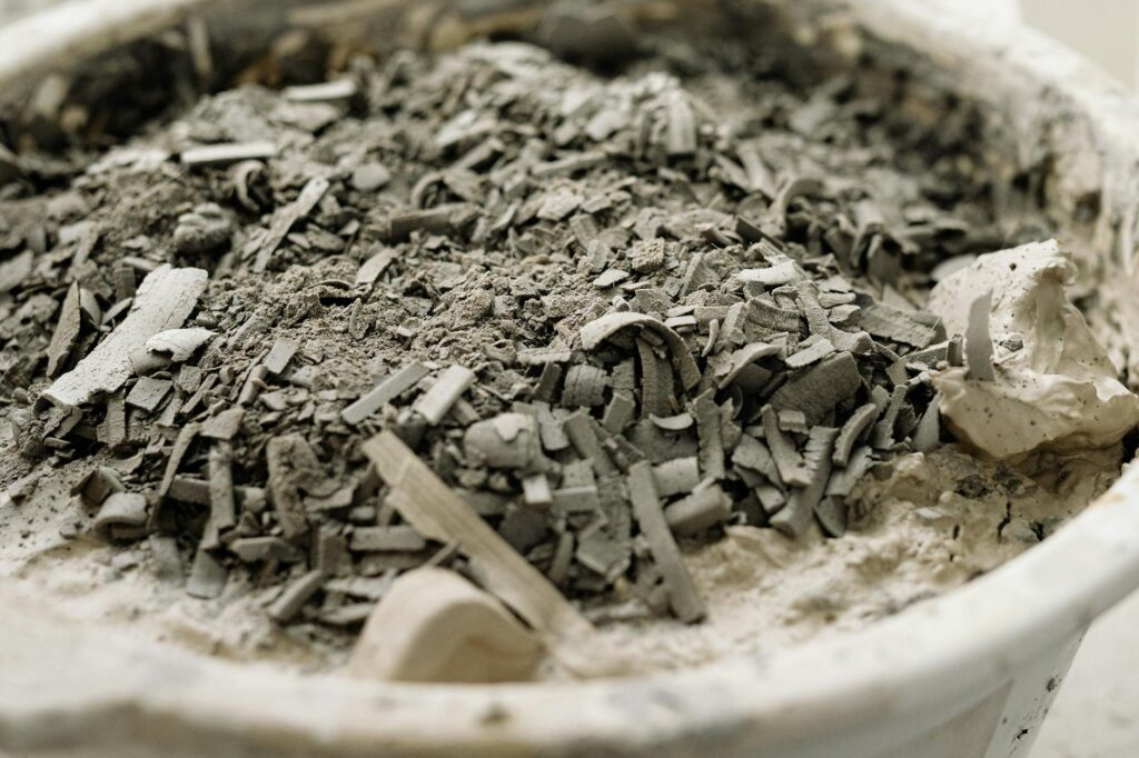 Detailed close-up of a white bowl filled with ashes and debris, highlighting texture.