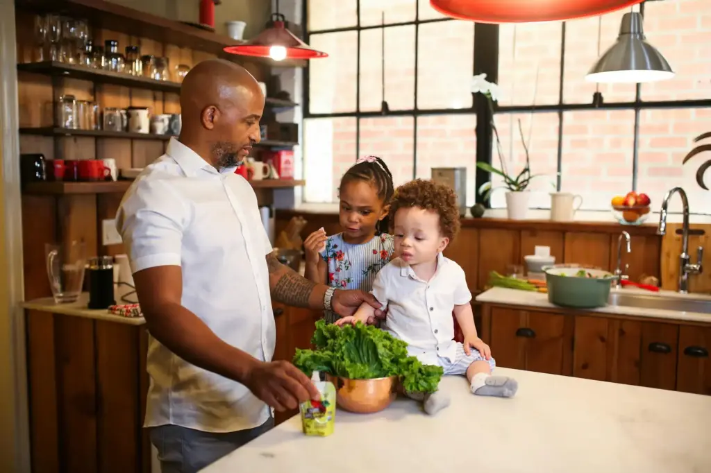 Father and children preparing a meal together in a cozy kitchen setting.