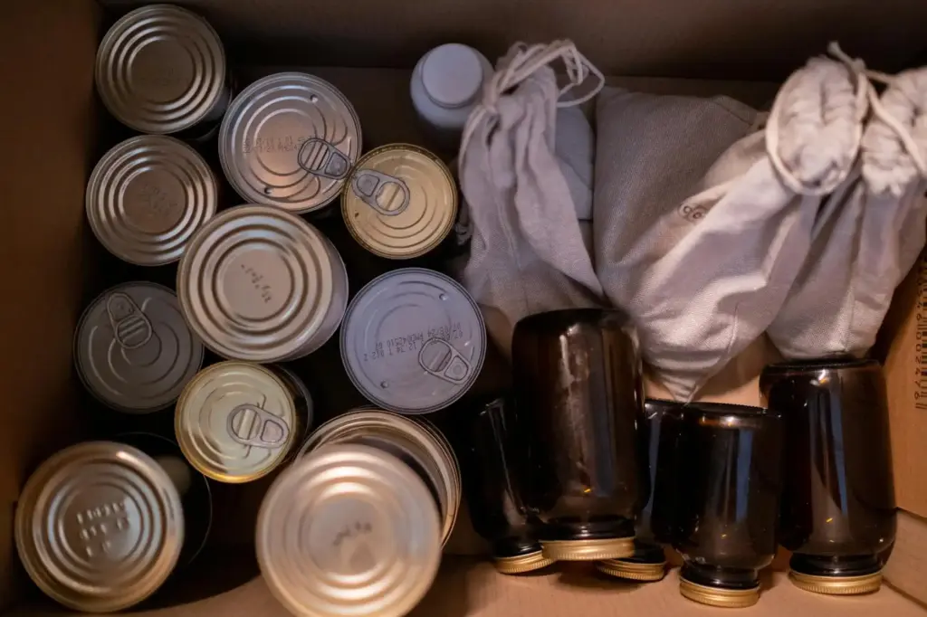 Top view of a box filled with canned goods, jars, and cloth sacks for storage.