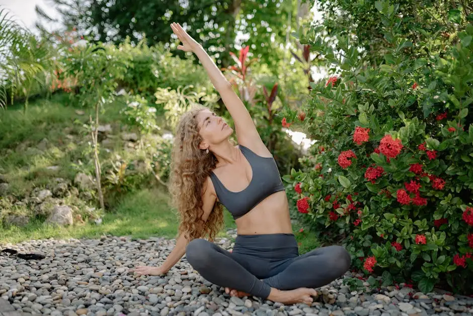 A woman practicing yoga outdoors in a serene garden with blooming red flowers, embodying peace and tranquility.