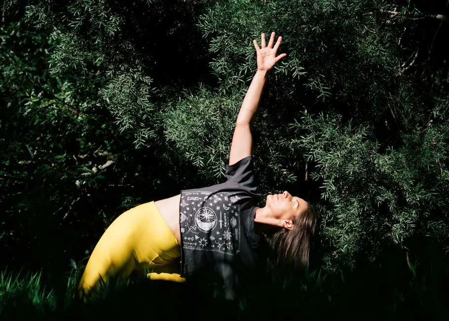 Woman practicing yoga in a peaceful outdoor setting with lush greenery.