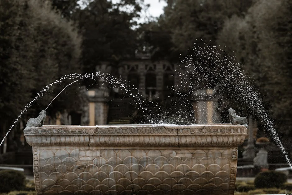 A beautifully crafted stone fountain splashes water in a tranquil garden setting.