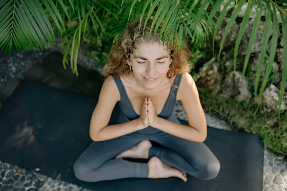 A serene scene of a woman meditating on a yoga mat surrounded by lush greenery.