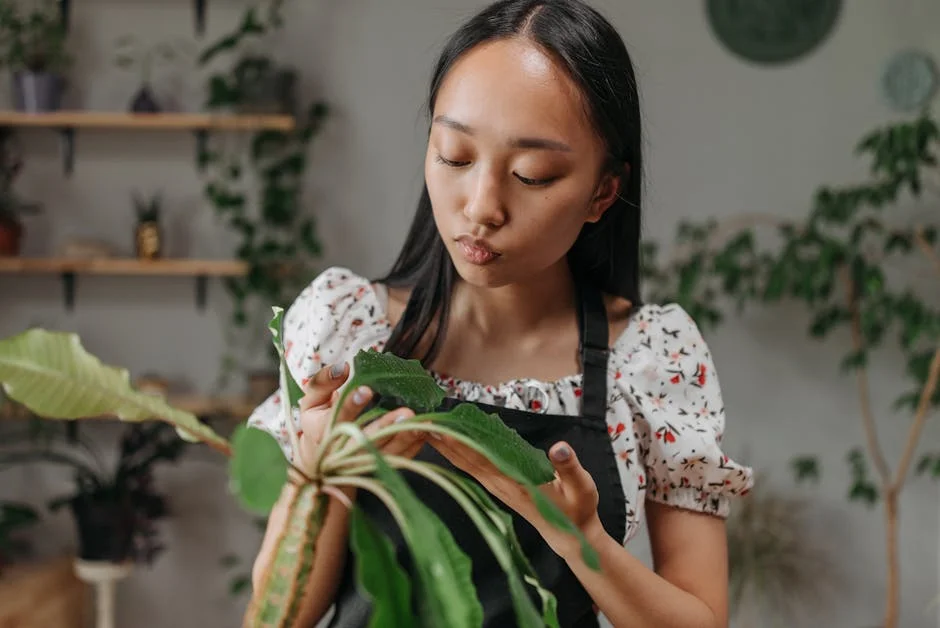 A young woman carefully examining a plant leaf indoors, promoting plant care and mindfulness.