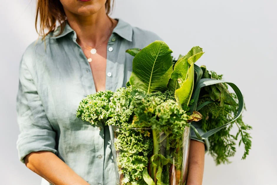 A woman in a light shirt carrying a basket of fresh greens, symbolizing healthy eating and lifestyle.