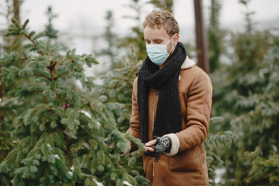 Person wearing mask in winter attire with spruce trees in background.