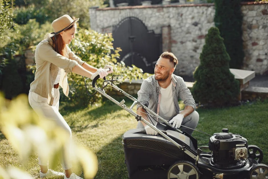 A cheerful couple working together in a garden with a lawn mower.