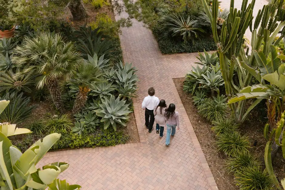 A family walks through a lush garden pathway, surrounded by diverse plants and greenery.