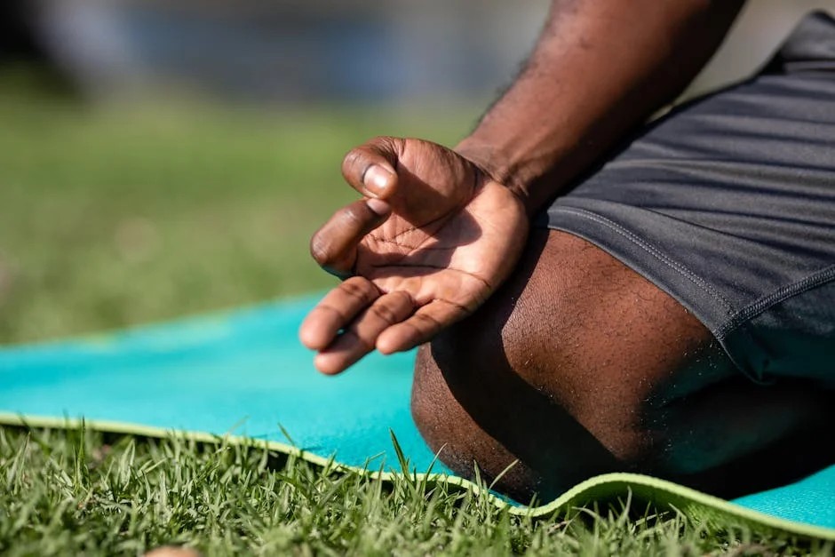 Focused meditation hand gesture on a blue yoga mat outdoors, highlighting mindfulness.