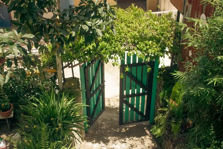 Aerial view of a green wooden gate amidst a garden full of lush plants and greenery.