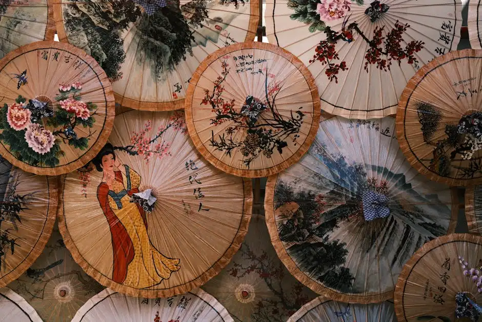 Close-up view of intricately decorated traditional Asian paper umbrellas with floral and figure designs.