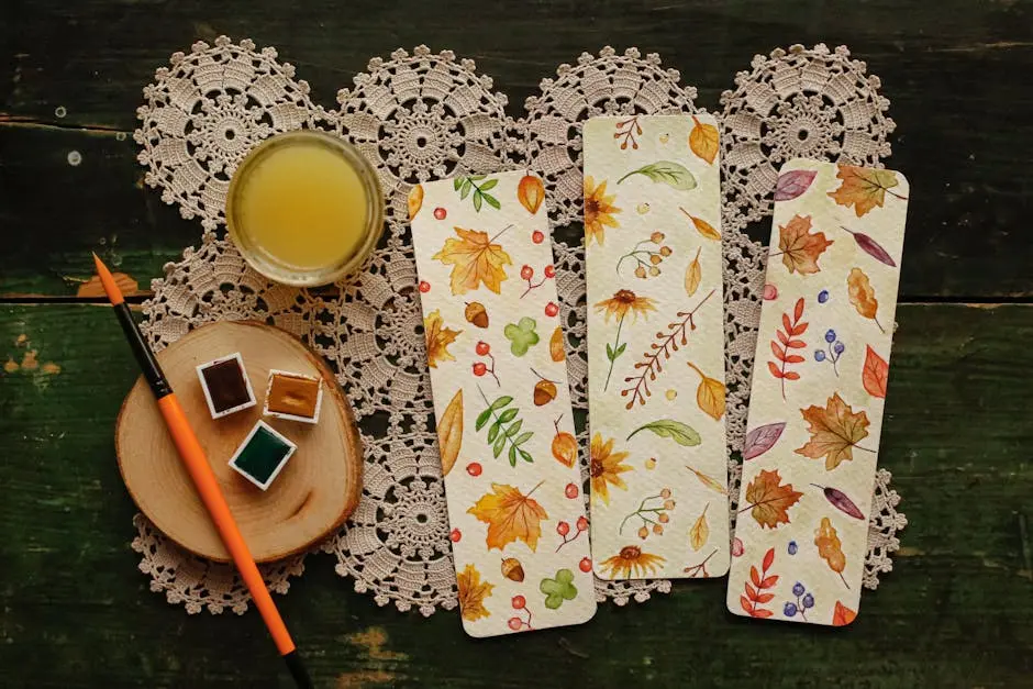Autumn-inspired bookmarks painted with watercolors on a rustic table setting.