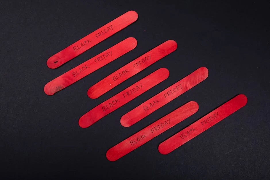 Red wooden sticks with Black Friday text on a black background, perfect for promotional visuals.
