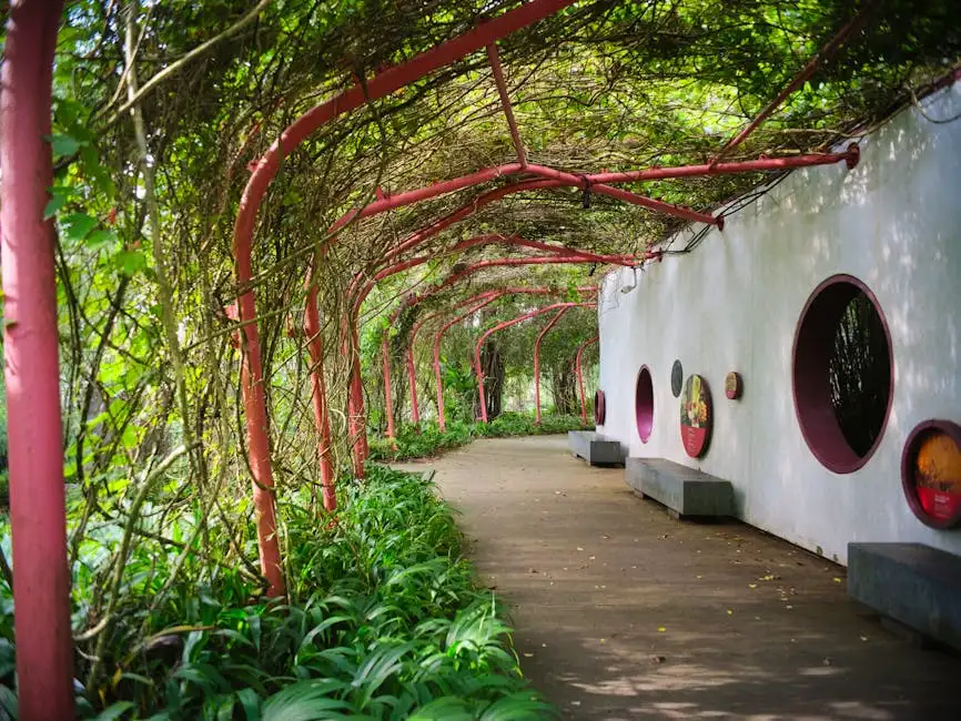 Serene outdoor path with red archways covered in greenery, ideal for peaceful walks.