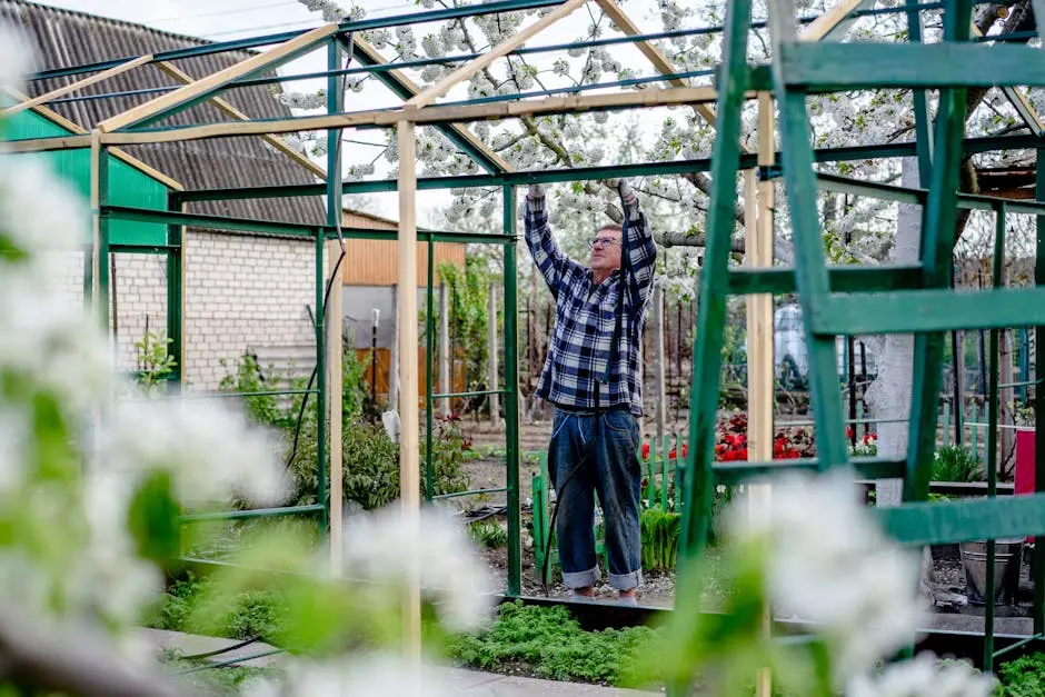 A man constructs a greenhouse surrounded by spring blossoms in Ukraine.