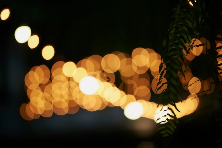 Abstract night photo featuring warm bokeh lights and green leaves, creating a tranquil atmosphere.