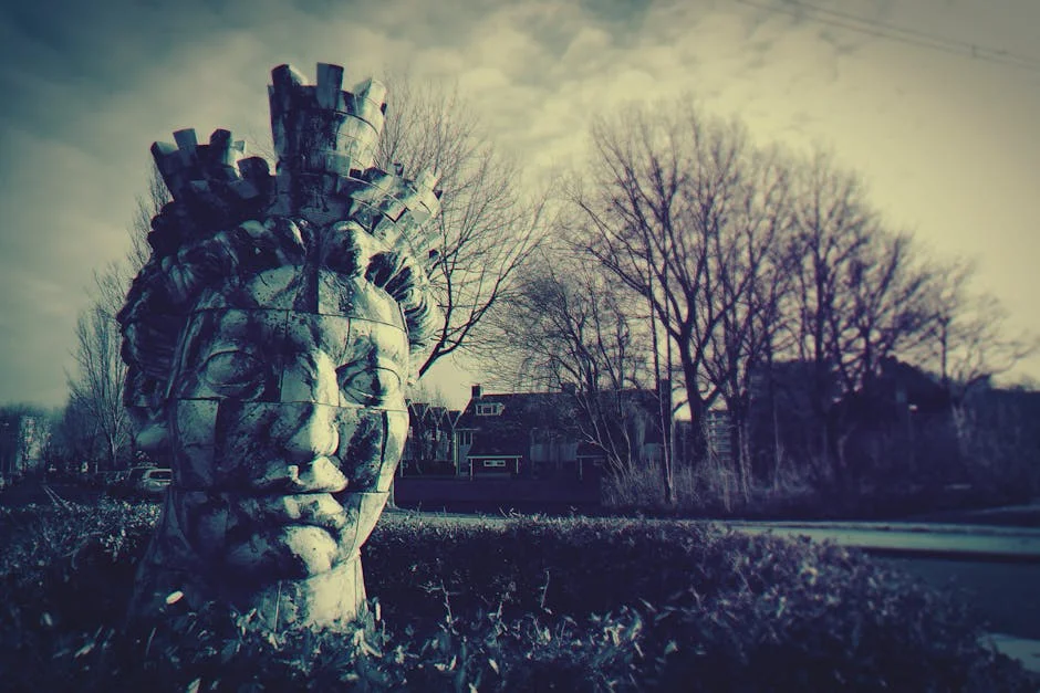 An eerie statue head in an ominous outdoor setting with barren trees and moody lighting.