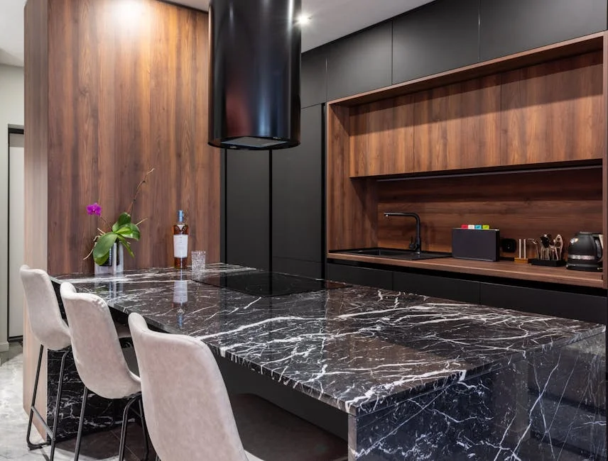 Sleek modern kitchen featuring a black marble countertop, wooden cabinets, and elegant lighting.