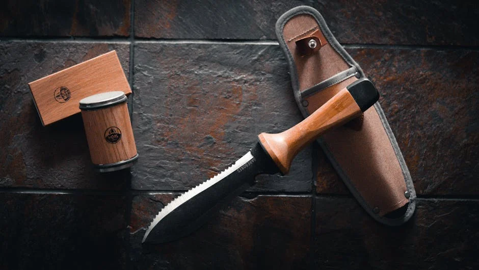 Elegant hori hori garden tool with matching wooden rolling sharpener for gardening enthusiasts.