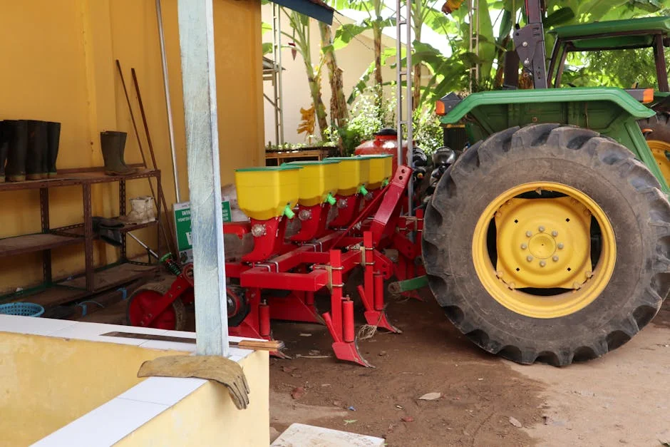 A tractor with a planter machine in a rural farm setting, showcasing essential farming equipment.