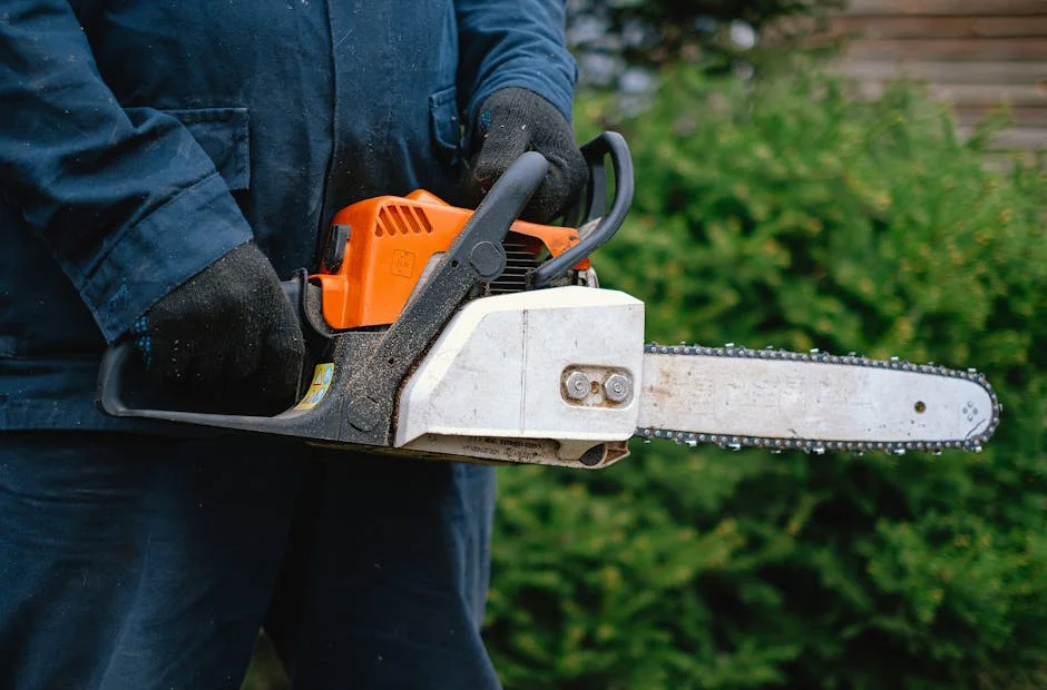 Close-up of a worker holding a chainsaw, highlighting carpentry tools and industry equipment.