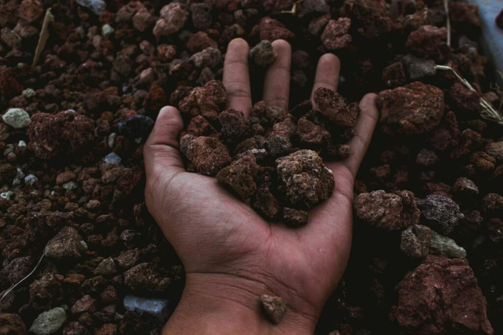 A detailed shot of a hand holding rocky soil, symbolizing earth and nature's raw beauty in Puebla, Mexico.