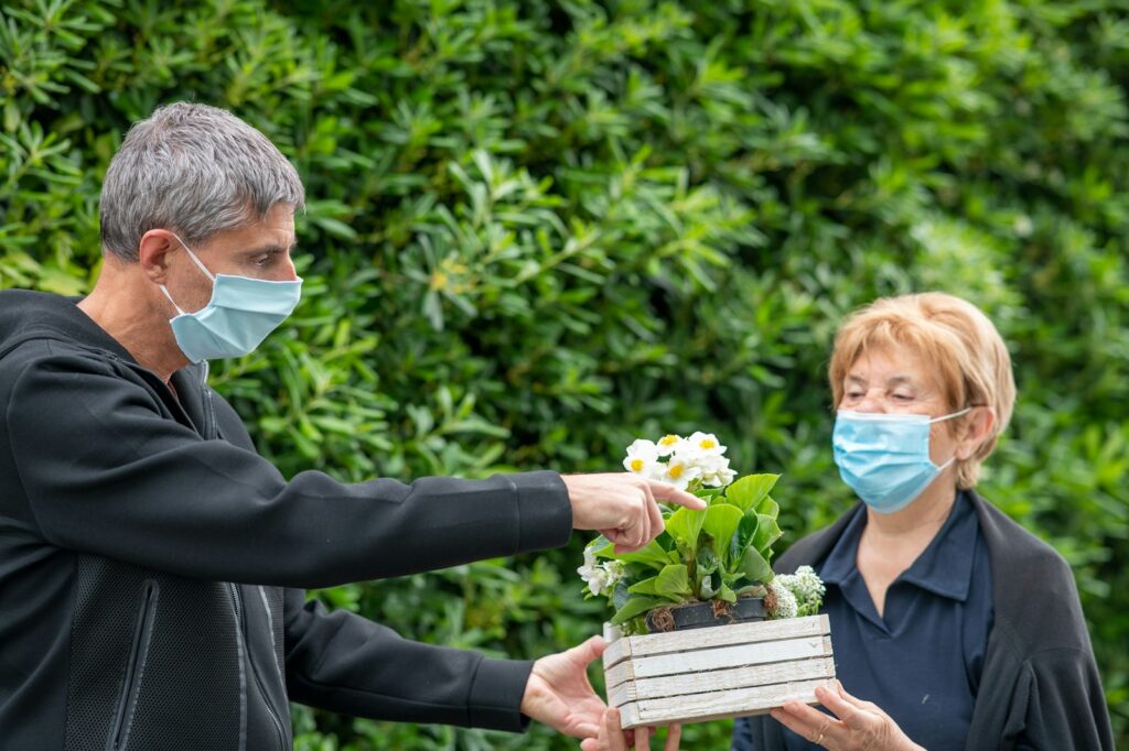 man in black suit jacket holding white flower bouquet