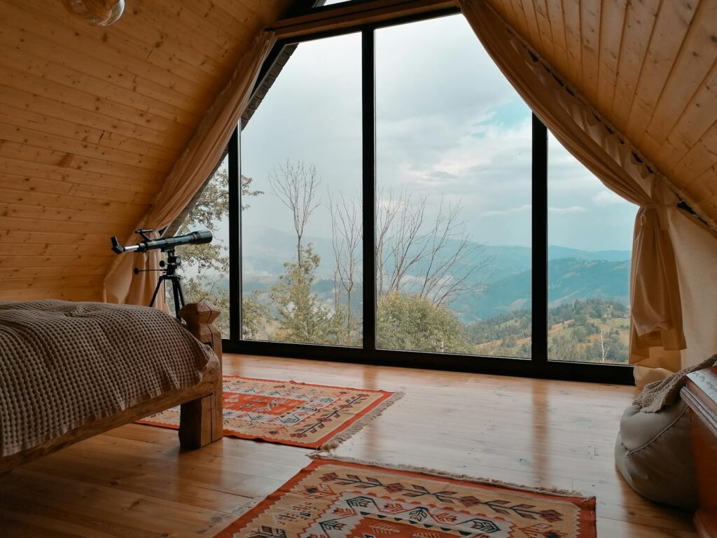 A tranquil wooden cabin interior with a telescope overlooking scenic mountains in Romania.