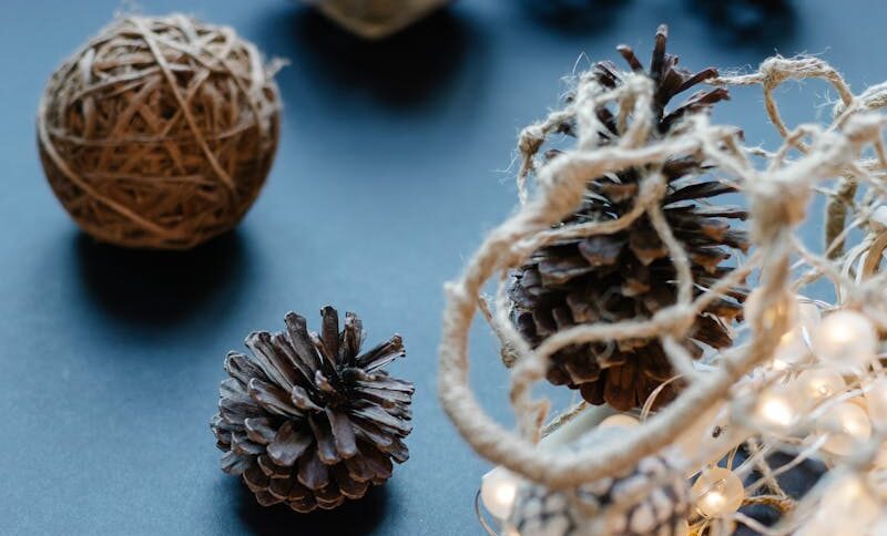 A decorative setup of pinecones, twine balls, and string lights for a cozy winter theme.