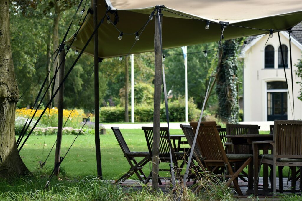 A table and chairs under a tent in the grass