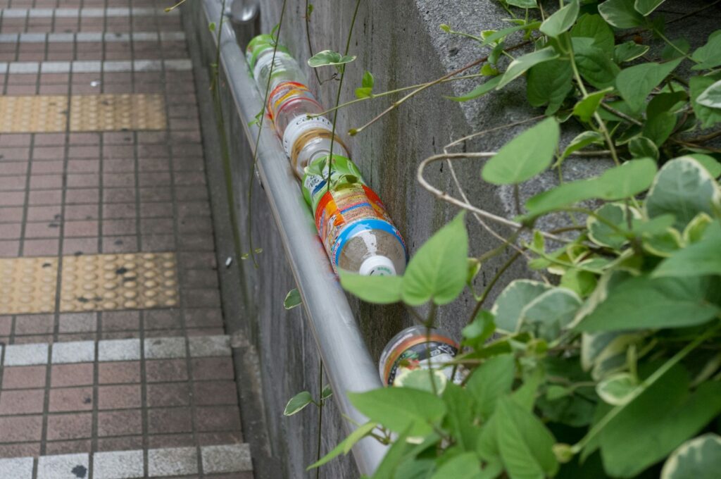 a row of empty water bottles sitting on the side of a building