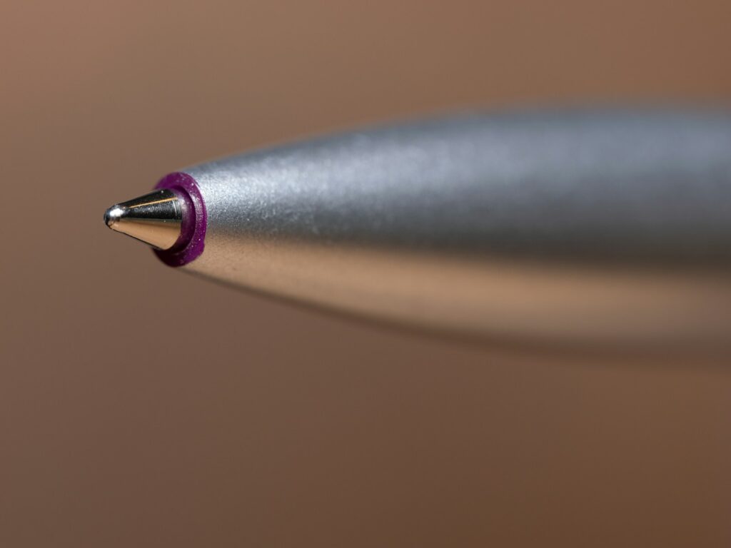 A close up of a pen with a red tip
