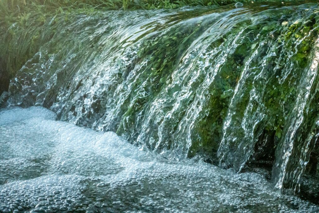 water falls on green grass field during daytime