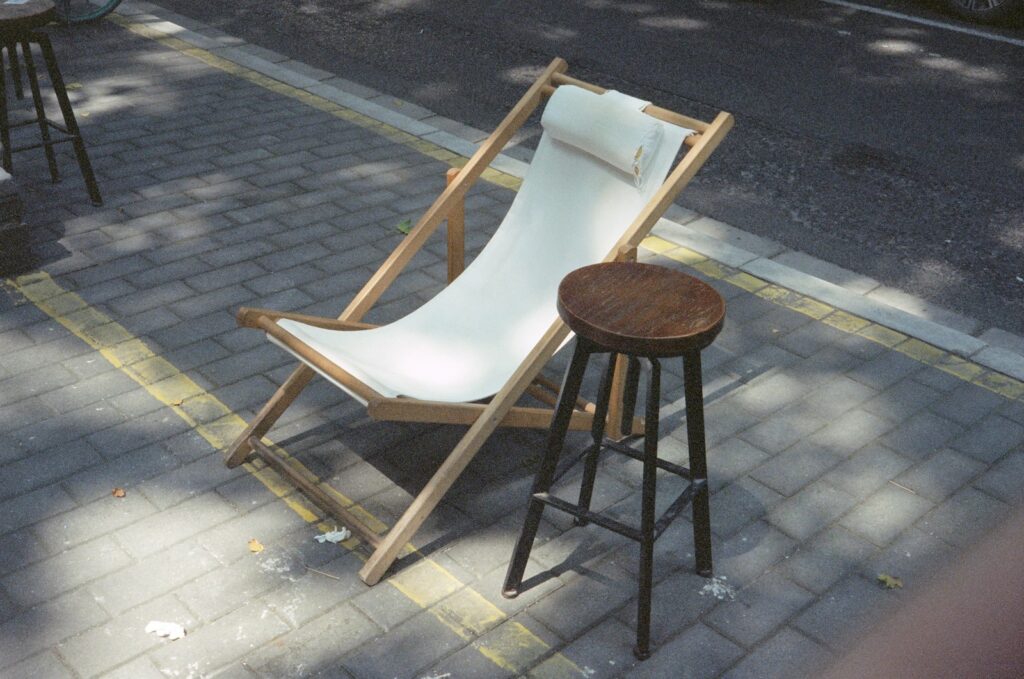 a chair and stool sitting on the side of the road