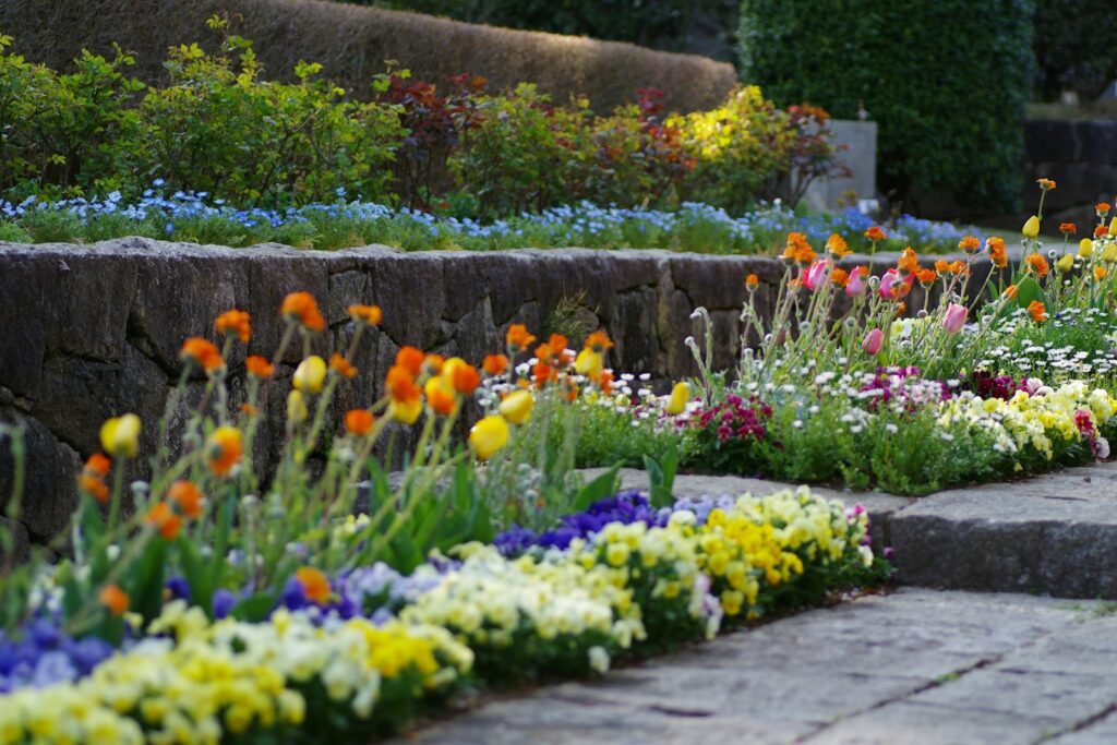 Colorful flowers bloom in a tiered garden bed.