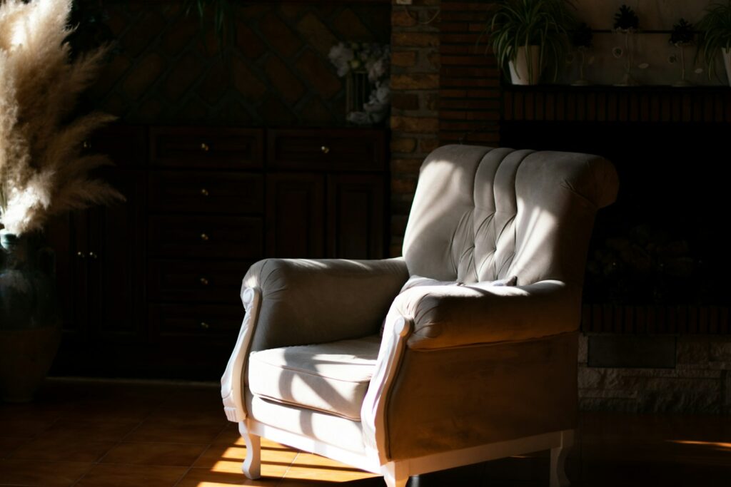 A sunlight chair sits next to a fireplace.