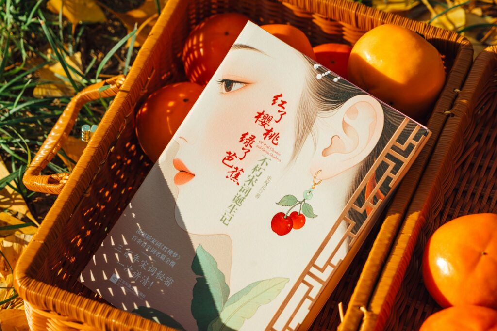 Book with cherries and persimmons in basket