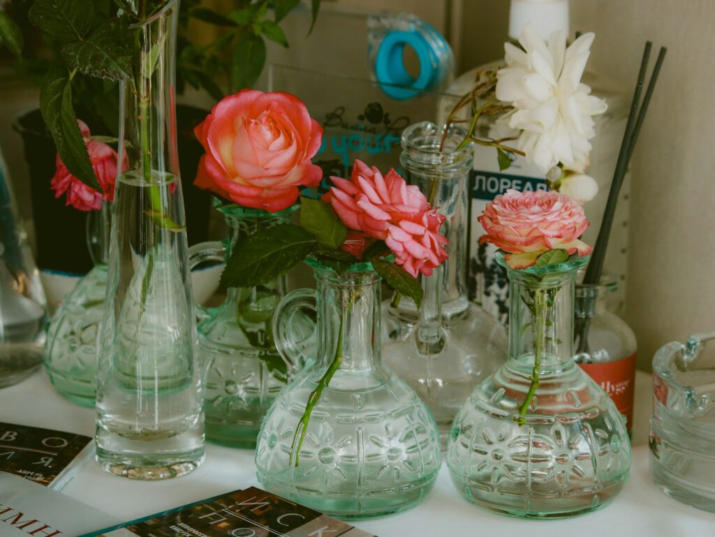 Vases of flowers are displayed on a shelf.