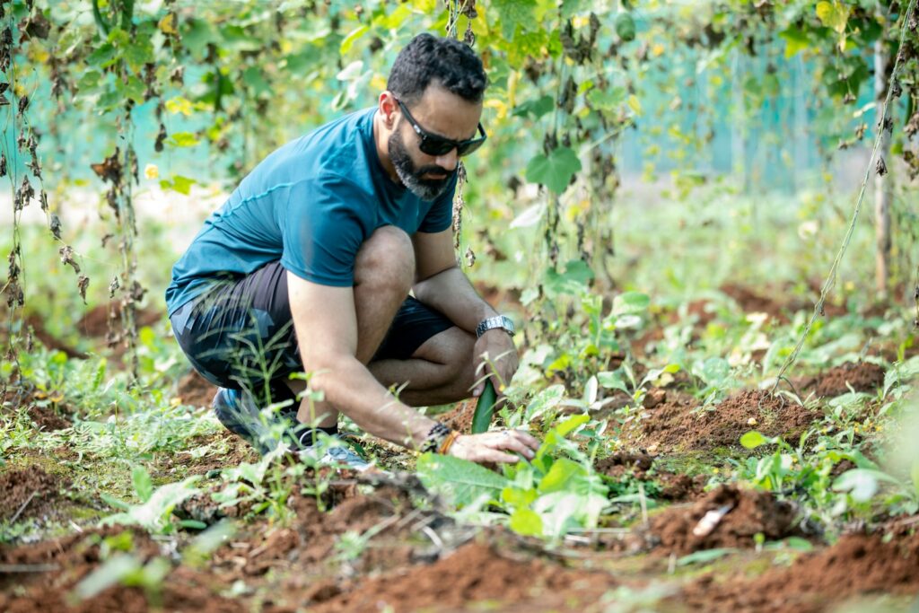 a man kneeling down in the middle of a field