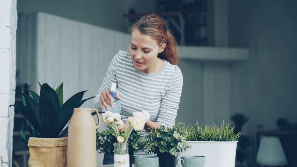 Woman watering plants on a balcony