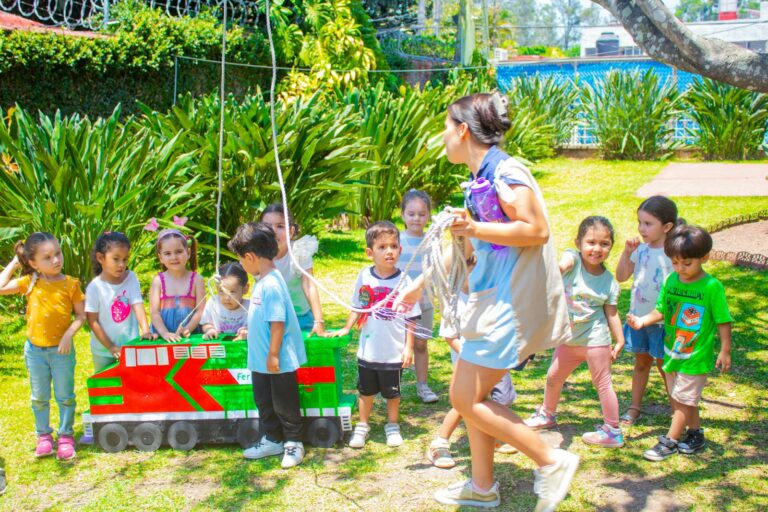 a group of children standing around a small train
