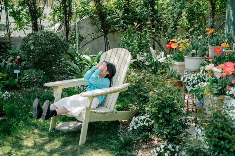 A woman relaxes in a sunny garden.