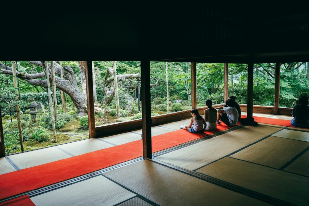 People sitting in a traditional japanese room overlooking garden