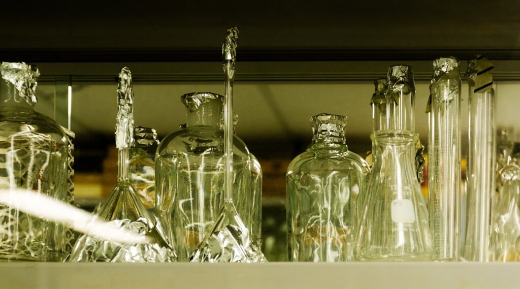 Lab glassware is displayed on a shelf.