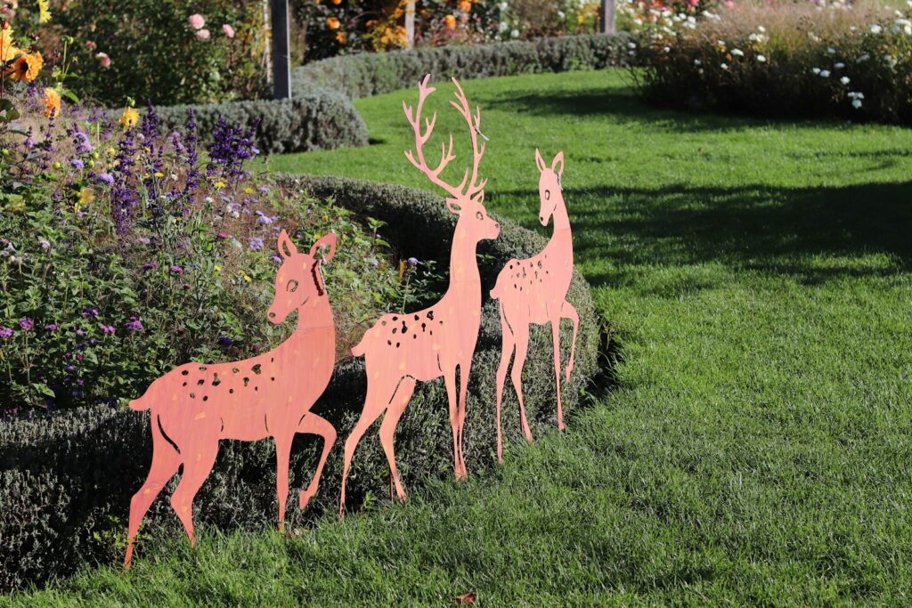 Three deer cutouts in a garden