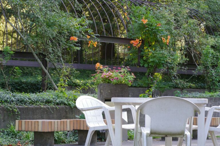 A group of white chairs sitting next to a wooden table