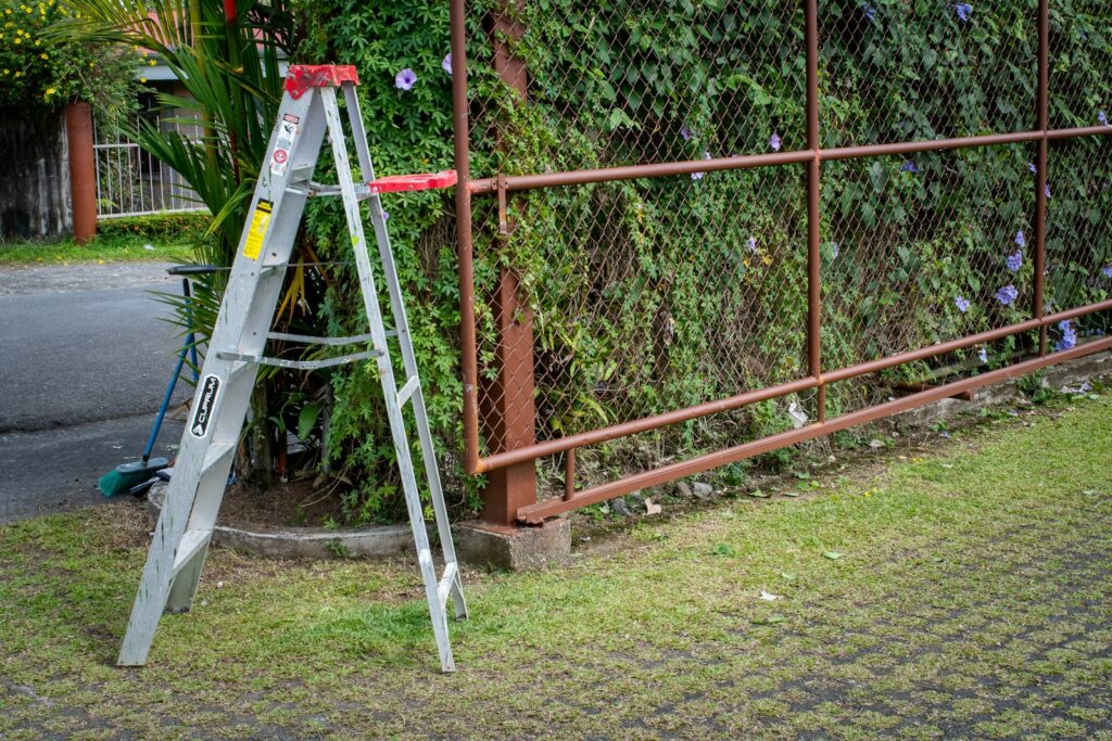 a ladder leaning against a fence next to a street