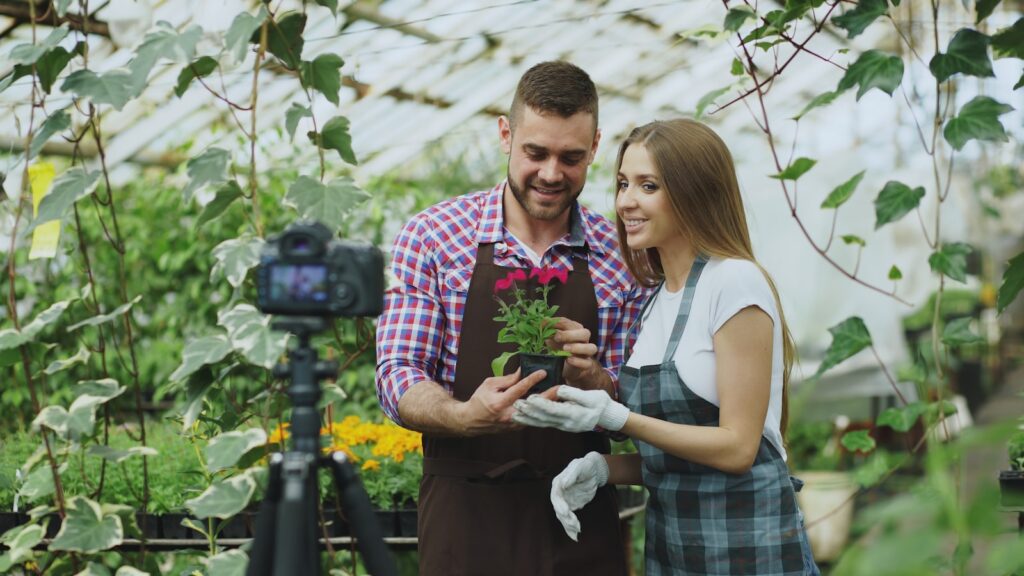 Couple filming themselves with a potted plant.