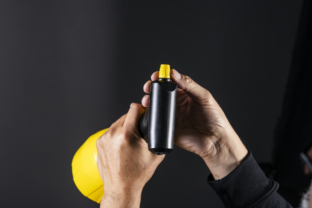 Person's hands holding a spray bottle.