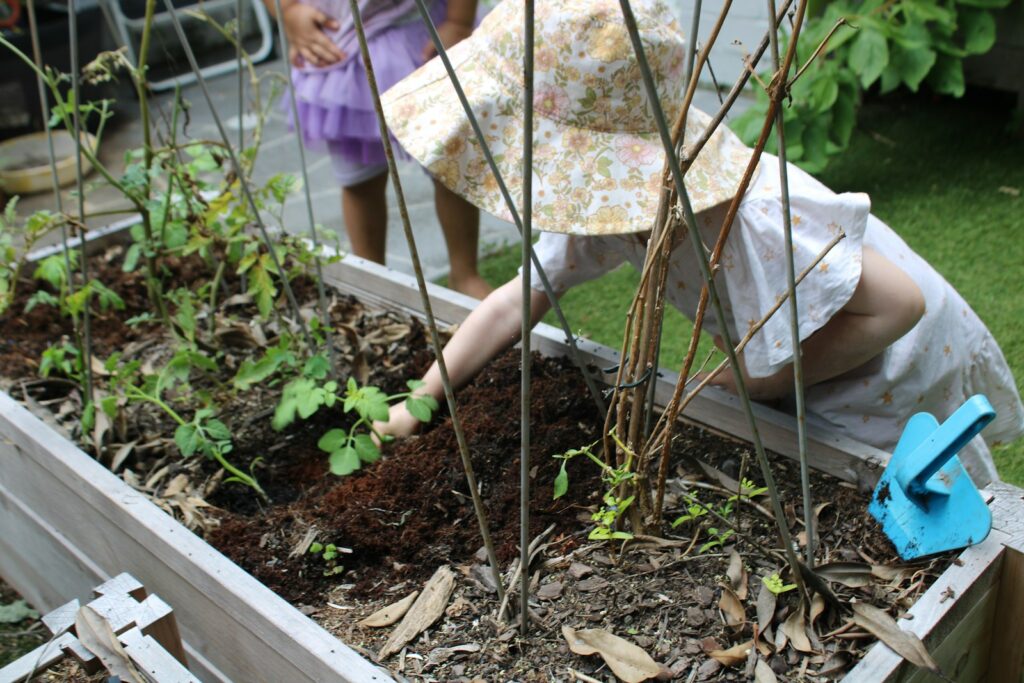 a little girl is digging in a garden